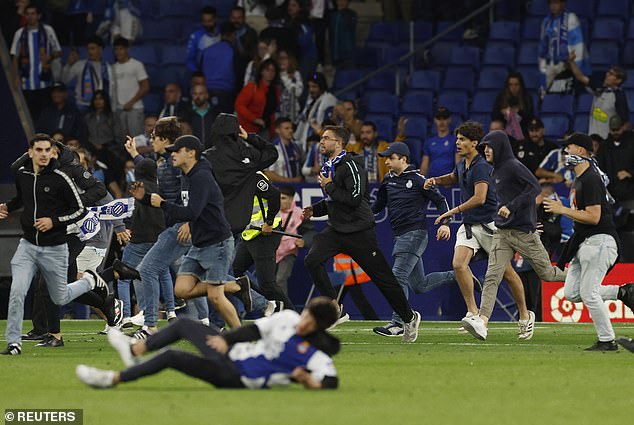 Ultras Espanyol menyerbu lapangan permainan untuk menghadapi pemain Barcelona. Foto: Daylimail